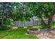 Landscaped backyard featuring raised garden beds, a brick fire pit, mature tree and lush green lawn at 9832 High St, Thornton, CO 80229