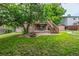 Exterior backyard view with fire pit, lush lawn, deck and mature tree offering ample shade at 9832 High St, Thornton, CO 80229