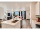 Bright, open-concept kitchen with stainless steel appliances, white cabinetry, and hardwood floors at 485 Bennett Ave, Bennett, CO 80102