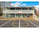 Two-story apartment with a white railed balcony and an outdoor half-court basketball court at 5761 W 71St Ave, Arvada, CO 80003