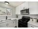 Well-lit kitchen featuring white cabinets, modern appliances, and a view from the window at 5761 W 71St Ave, Arvada, CO 80003