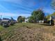 Large back yard with mature trees, deck, partial wooden fence, brick and concrete pad at 5886 S Nepal Way, Centennial, CO 80015