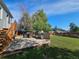 Backyard deck with wooden railing features an outdoor table, chairs, and a grill at 5886 S Nepal Way, Centennial, CO 80015