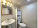 Cozy bathroom with sink, toilet, white storage unit, vanity lights and fan at 5886 S Nepal Way, Centennial, CO 80015