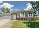 Charming home featuring a two-car garage, stone accents, pristine lawn, and lovely curb appeal at 5886 S Nepal Way, Centennial, CO 80015