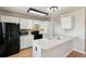 Bright kitchen featuring white cabinets, black appliances, and a functional peninsula counter at 5886 S Nepal Way, Centennial, CO 80015