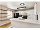 Well-lit kitchen featuring white cabinets, modern appliances, and custom open shelving near window at 5886 S Nepal Way, Centennial, CO 80015
