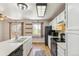 Bright kitchen features white cabinets, wood floors, and a sink with windows looking out to a balcony at 5886 S Nepal Way, Centennial, CO 80015