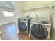 Modern washer and dryer with shelf above in laundry area with hardwood floors at 5886 S Nepal Way, Centennial, CO 80015