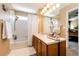 Bright bathroom features shower-tub, large mirror and wooden vanity at 2070 E 125Th Pl, Thornton, CO 80241