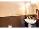 Half bathroom features two-tone paint, modern sink and round mirror at 2070 E 125Th Pl, Thornton, CO 80241