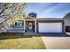 Charming home showcasing a two-car garage and well-maintained front yard with flower tree in full bloom at 2070 E 125Th Pl, Thornton, CO 80241