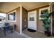 Inviting front porch featuring a seating area, potted plant, and a white front door at 2070 E 125Th Pl, Thornton, CO 80241