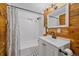 Farmhouse bathroom with wood accent wall, shower with white subway tile, and black fixtures at 80 Castlewood Ct, Evergreen, CO 80439