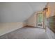 Bright bedroom featuring an attic roof, a double window door, and neutral walls and carpet at 80 Castlewood Ct, Evergreen, CO 80439