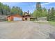 Exterior of home with a detached garage, a greenhouse and spacious yard at 80 Castlewood Ct, Evergreen, CO 80439