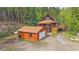 Exterior of the cabin home featuring a detached garage and lovely landscape at 80 Castlewood Ct, Evergreen, CO 80439