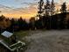 Scenic view of a greenhouse with a white fence and a sunset backdrop at 80 Castlewood Ct, Evergreen, CO 80439