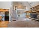Open-concept living room with high ceilings, a stone fireplace, and staircase to loft at 80 Castlewood Ct, Evergreen, CO 80439