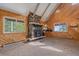 Cozy living room featuring stone fireplace, wood paneling, and scenic window views at 80 Castlewood Ct, Evergreen, CO 80439