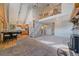 Open-concept living room with stone fireplace, wood floors, and adjacent kitchen area at 80 Castlewood Ct, Evergreen, CO 80439
