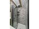 Modern shower featuring gray tiling, a rainfall shower head, and wooden accents at 80 Castlewood Ct, Evergreen, CO 80439