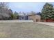 Wide view of the backyard and exterior of a two-story home featuring multiple windows and brick at 6389 S Ponds Way, Littleton, CO 80123