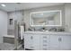 Modern bathroom with double vanity, illuminated mirror, and walk-in shower with tiled bench at 6389 S Ponds Way, Littleton, CO 80123