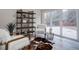 Bright living area with a cowhide rug, modern shelving, and sliding glass doors to the backyard at 6389 S Ponds Way, Littleton, CO 80123