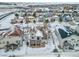 Aerial view of house and neighborhood in snowy setting at 12198 Tack Dr, Parker, CO 80134