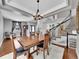 Bright dining room with hardwood floors, a chandelier and views into the living room and entryway at 12198 Tack Dr, Parker, CO 80134