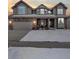 Two-story house with stone accents, a covered porch, and a snowy lawn at 12198 Tack Dr, Parker, CO 80134