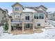 Two-story home exterior with a large deck and snowy yard at 12198 Tack Dr, Parker, CO 80134