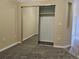 Bedroom featuring mirrored closet doors and neutral walls over carpeted floor at 15475 E Andrews Dr # 402, Denver, CO 80239