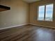 Bedroom featuring a large window and neutral walls over hardwood floors at 15475 E Andrews Dr # 402, Denver, CO 80239