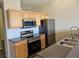 Well-lit kitchen featuring wood cabinetry, stainless steel appliances, and a modern sink fixture at 15475 E Andrews Dr # 402, Denver, CO 80239