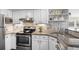 Well-lit kitchen featuring stainless appliances and stone backsplash at 4760 S Wadsworth Blvd # K205, Littleton, CO 80123