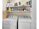 Convenient laundry room featuring a side-by-side washer and dryer with shelving at 4760 S Wadsworth Blvd # K205, Littleton, CO 80123