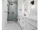 This modern bathroom featuring white cabinets, marble countertops, and a glass shower at 2361 Junegrass Ln, Louisville, CO 80027