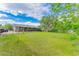 A serene backyard featuring a lush green lawn, some trees and a covered patio perfect for outdoor relaxation at 2630 W Asbury Ave, Denver, CO 80219