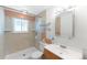 Updated bathroom featuring tiled walls, a walk-in shower, and a vanity with storage at 2630 W Asbury Ave, Denver, CO 80219