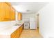 Functional kitchen with light wood cabinetry, white appliances, and easy-to-clean tile floors at 2630 W Asbury Ave, Denver, CO 80219