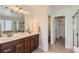 Double vanity bathroom with modern lighting and a walk-in closet nearby at 17040 Galapago Ct, Broomfield, CO 80023