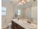 Bright bathroom with double sinks, vanity with dark wood cabinets, and a large framed mirror at 17040 Galapago Ct, Broomfield, CO 80023