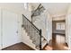 Elegant foyer with dark hardwood flooring, a staircase with wrought iron railings, and a view into the living spaces at 17040 Galapago Ct, Broomfield, CO 80023