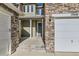 Inviting front porch featuring stone accents, white columns, and a charming front door at 17040 Galapago Ct, Broomfield, CO 80023