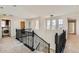 Hallway with black metal staircase railing, carpet, light fixtures, and an open view to other rooms at 17040 Galapago Ct, Broomfield, CO 80023