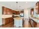 Gourmet kitchen featuring dark wood cabinetry, granite countertops, a central island, and stainless steel appliances at 17040 Galapago Ct, Broomfield, CO 80023