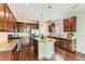 Modern kitchen featuring dark wood cabinets, granite countertops, an island with pendant lighting, and stainless steel appliances at 17040 Galapago Ct, Broomfield, CO 80023