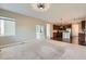 Open-concept living room flowing into the kitchen, featuring neutral decor and modern lighting fixtures at 17040 Galapago Ct, Broomfield, CO 80023